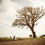 man-and-woman-standing-on-brown-field-near-green-tree-under-3990371
